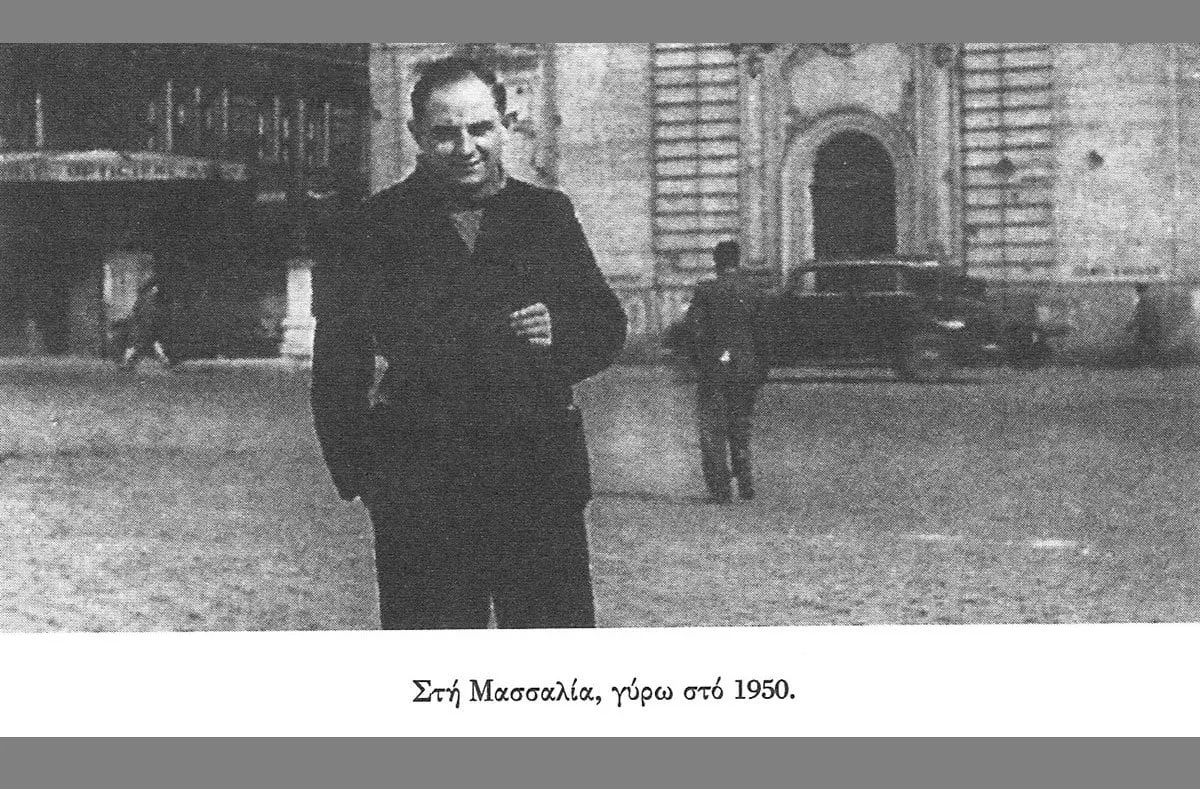 Ο Νίκος Καββαδίας στέκεται σε πλατεία της Μασσαλίας με σκούρο παλτό, γύρω στο 1950