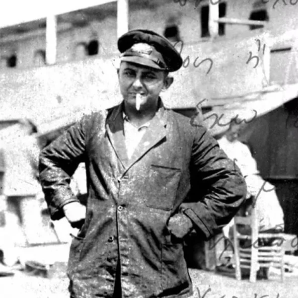 Ο Νίκος Καββαδίας με ναυτική στολή και μπερέ στο κατάστρωμα πλοίου, με τη θάλασσα πίσω του