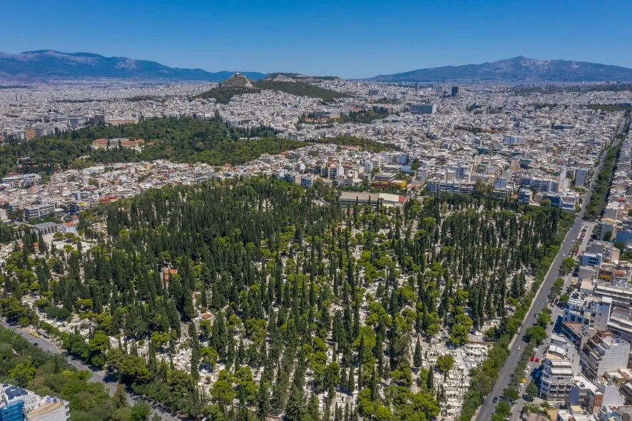 Μαρμάρινα μνημεία και δέντρα στο Α΄ Νεκροταφείο Αθηνών, στην πλαγιά του λόφου του Αρδηττού