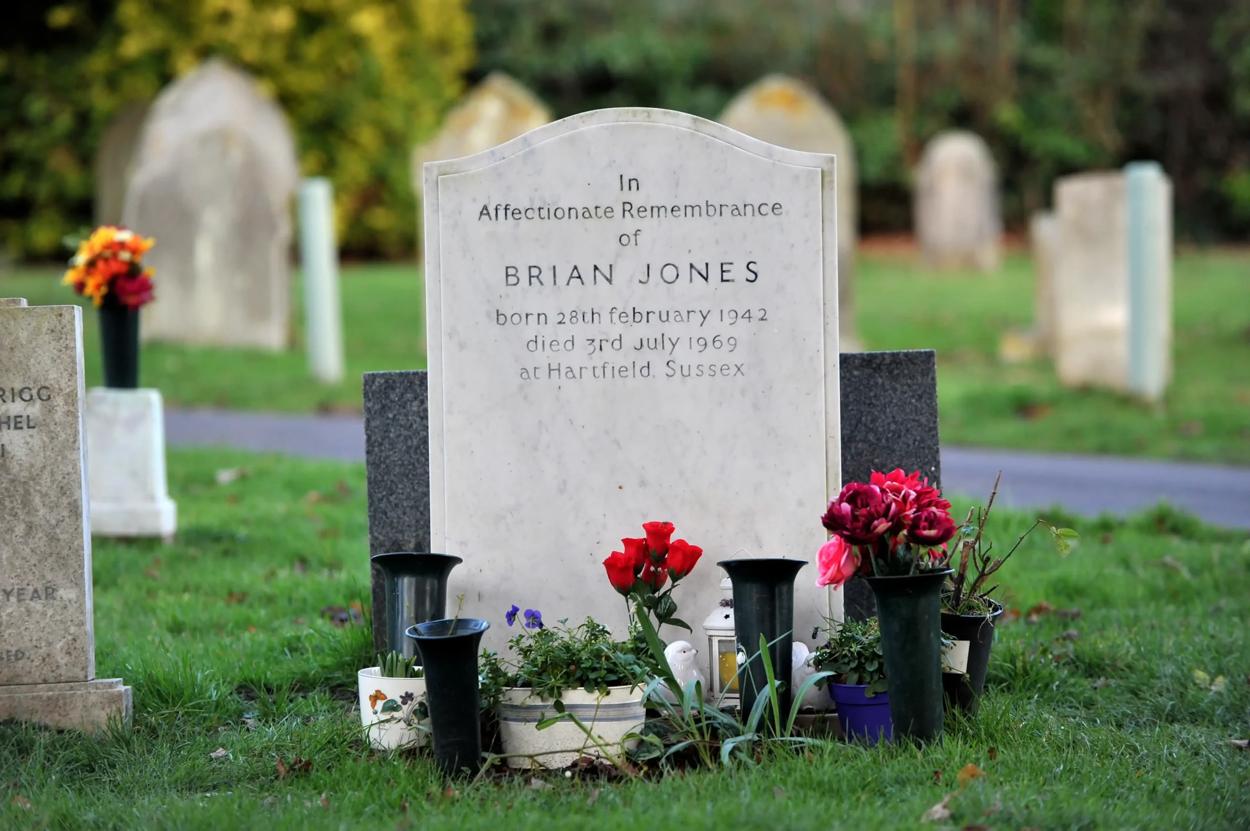 Η επιτύμβια πλάκα του Brian Jones στο Cheltenham Cemetery, με λουλούδια και μικρά αφιερώματα.