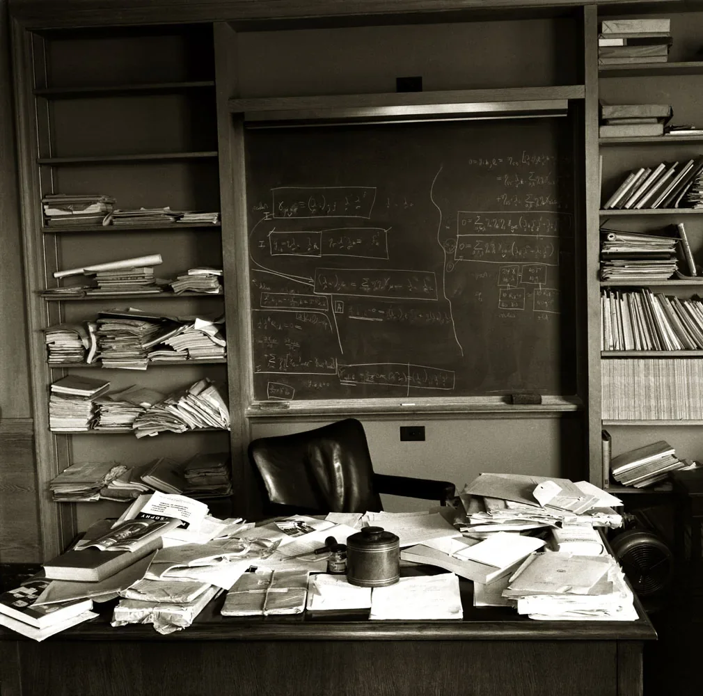 Το γραφείο του Albert Einstein στο Institute for Advanced Study, με μαυροπίνακα γεμάτο εξισώσεις, ράφια με χαρτιά και μια δερμάτινη καρέκλα