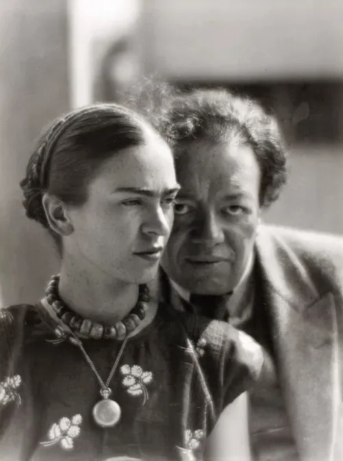 Ασπρόμαυρο κοντινό πορτρέτο της Frida Kahlo και του Diego Rivera, με την Kahlo να κοιτάζει στο πλάι και τον Rivera πίσω της