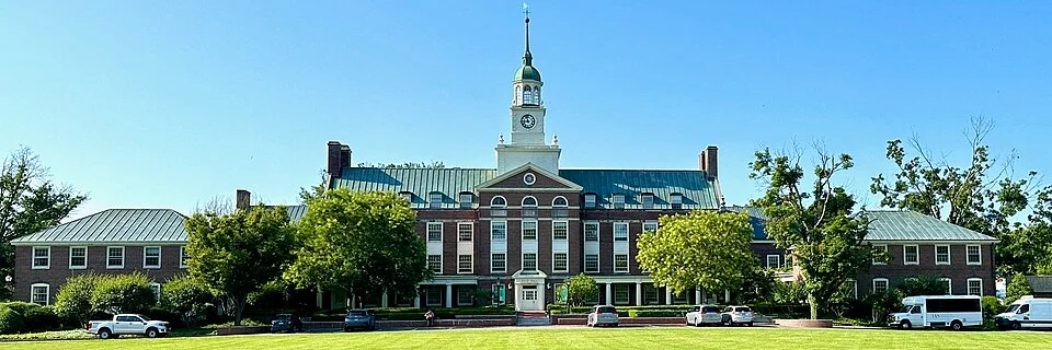Το κτίριο Fuld Hall του Institute for Advanced Study στο Πρίνστον, με κόκκινα τούβλα, λευκό καμπαναριό με ρολόι και πράσινο γκαζόν μπροστά