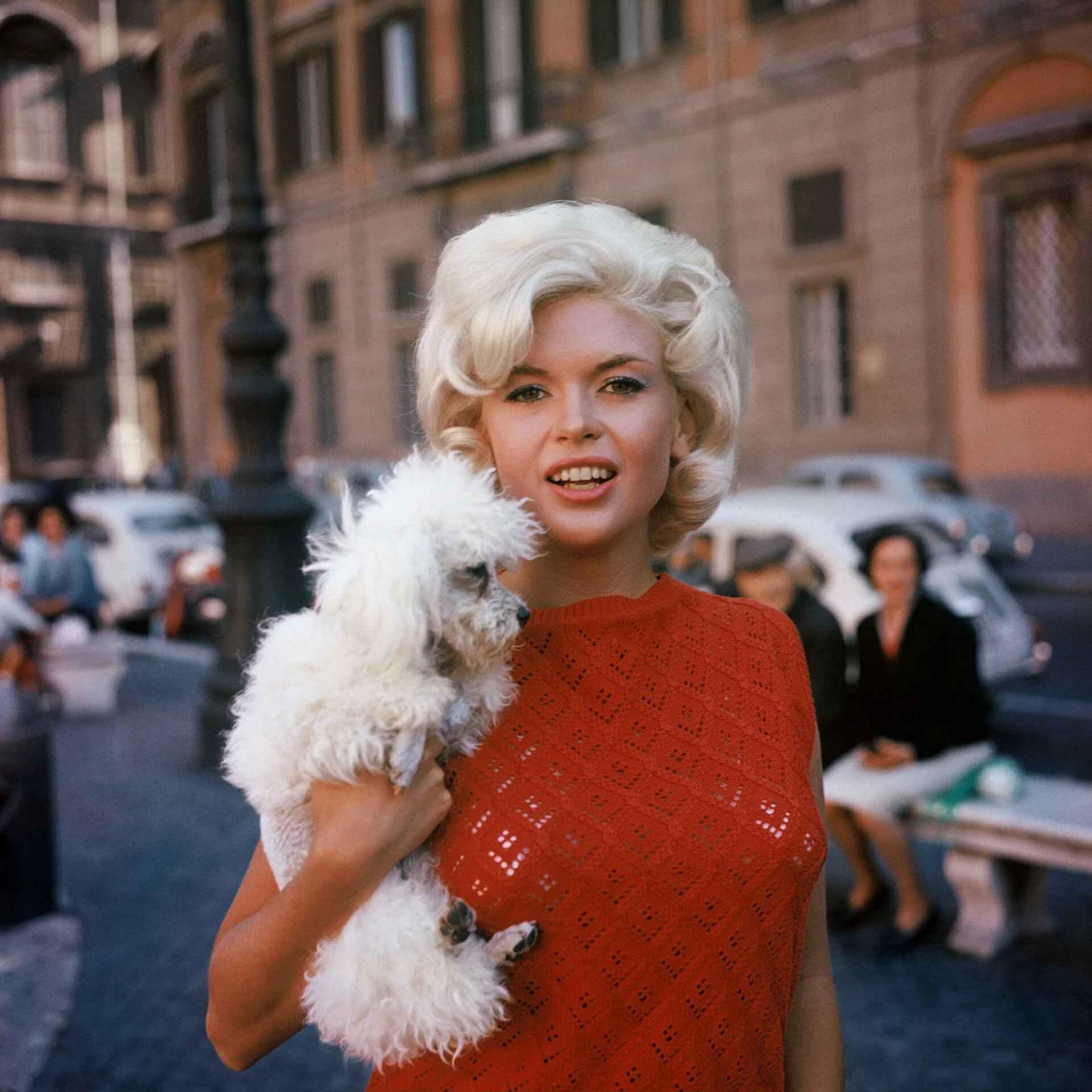 Η Jayne Mansfield κρατά ένα μικρό λευκό σκυλί σε δρόμο