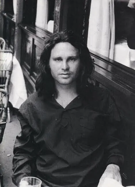 Ασπρόμαυρο πορτρέτο του Jim Morrison καθισμένου δίπλα σε παράθυρο