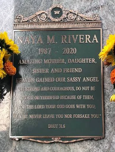 Η μπρούντζινη πλάκα στον τάφο της Naya Rivera, 1987–2020, με λουλούδια εκατέρωθεν
