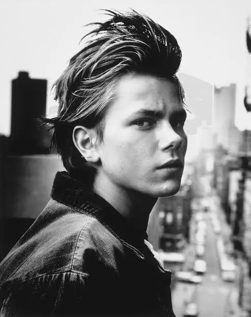 Ασπρόμαυρο πορτρέτο του River Phoenix με φόντο την πόλη