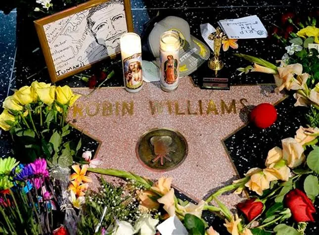 Το αστέρι του Robin Williams στη Λεωφόρο της Δόξας του Χόλιγουντ, καλυμμένο με λουλούδια, κεριά, ένα κορνιζαρισμένο σκίτσο και μια μικρή κοπή αγαλματιδίου Όσκαρ