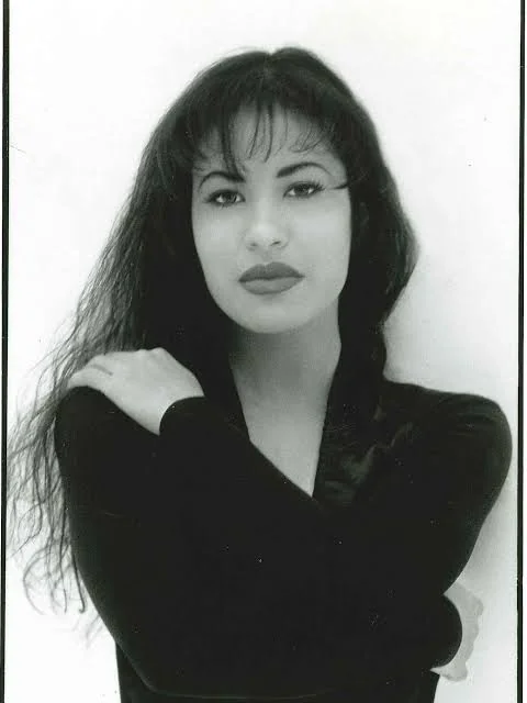 Ασπρόμαυρο πορτρέτο της Selena με μακριά σκούρα μαλλιά και μαύρη μπλούζα
