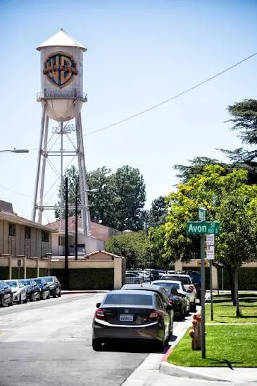 Ο υδατόπυργος της Warner Bros. με το λογότυπο WB πάνω από δρόμο με σταθμευμένα αυτοκίνητα, στο Burbank