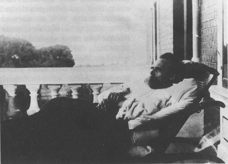 Ο Friedrich Nietzsche ξαπλωμένος σε πολυθρόνα σε μπαλκόνι με κιγκλίδωμα, με την αυλή στο βάθος