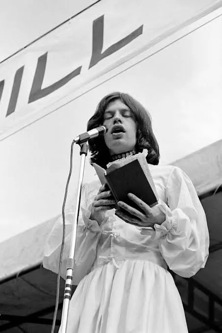 Ο Mick Jagger διαβάζει από βιβλίο μπροστά σε μικρόφωνο στο Hyde Park.