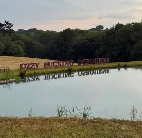 Λίμνη σε καταπράσινο κτήμα, με το όνομα του Ozzy Osbourne γραμμένο με λουλούδια στην όχθη