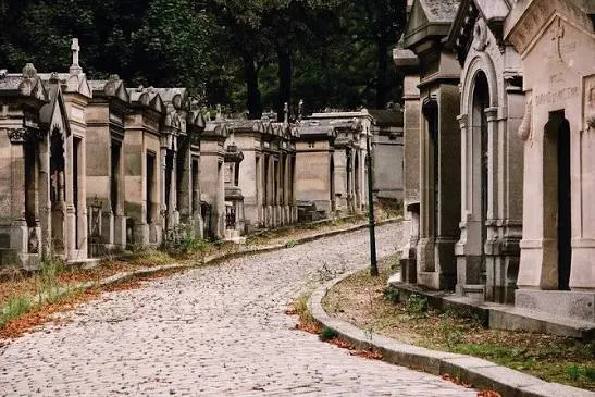 Στενός πλακόστρωτος δρόμος με πέτρινους τάφους και φθινοπωρινά φύλλα στο Περ Λασαίζ