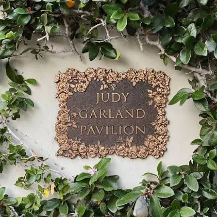 Η χάλκινη πλάκα Judy Garland Pavilion, με ανάγλυφα τριαντάφυλλα, μέσα σε κισσό